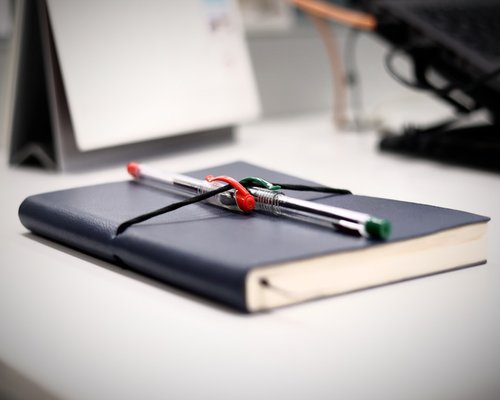 Notizbuch und Stift auf einem aufgeräumten Schreibtisch